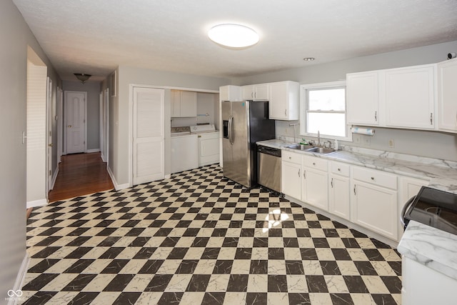 kitchen with a sink, separate washer and dryer, white cabinetry, and stainless steel appliances