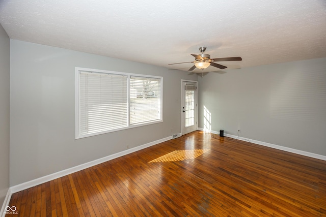 spare room featuring baseboards, a textured ceiling, a ceiling fan, and hardwood / wood-style flooring