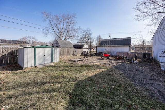 view of yard with an outbuilding, a storage shed, and a fenced backyard