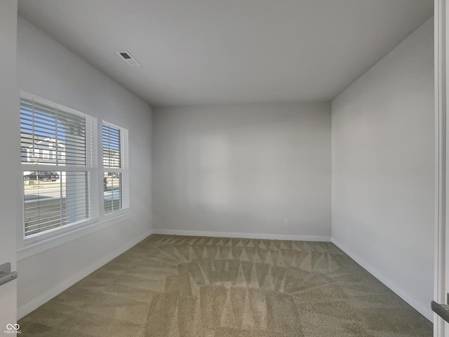 carpeted empty room with visible vents and baseboards