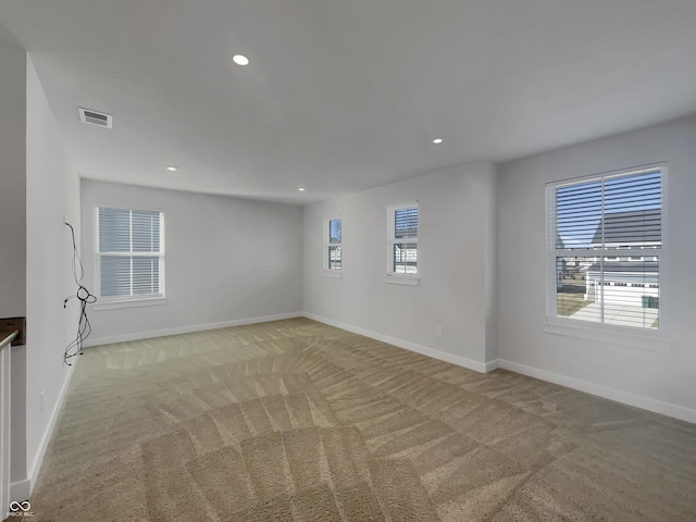 unfurnished room featuring light carpet, visible vents, recessed lighting, and baseboards