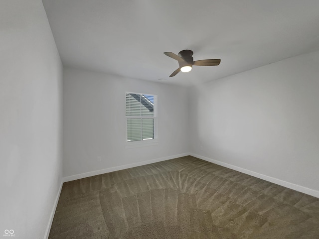 empty room with baseboards, ceiling fan, and dark carpet