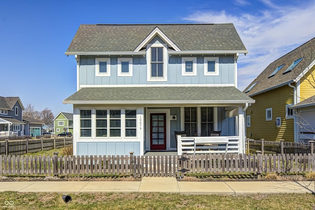 view of front facade featuring board and batten siding, covered porch, and roof with shingles