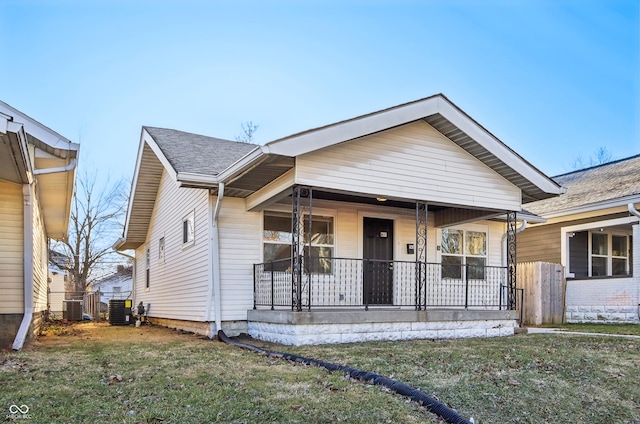 bungalow featuring a porch, a front lawn, and central AC