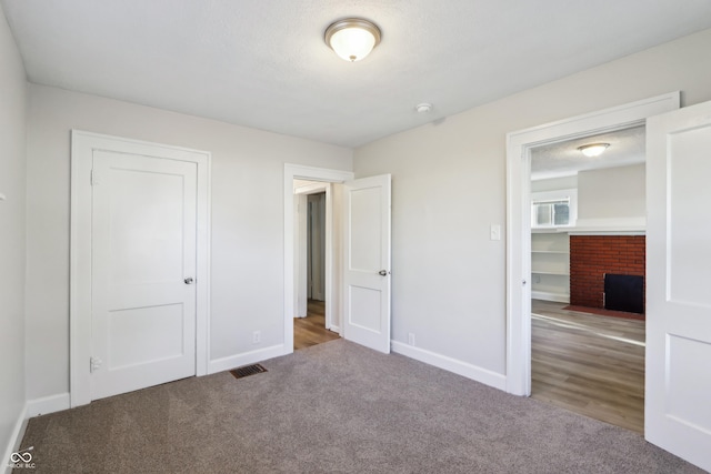 unfurnished bedroom featuring visible vents, baseboards, a closet, and carpet flooring