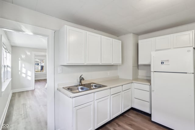 kitchen with freestanding refrigerator, a sink, dark wood-type flooring, light countertops, and white cabinetry