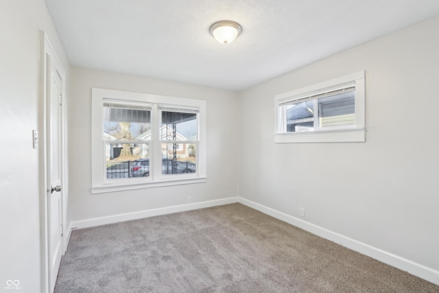 unfurnished room featuring carpet and baseboards