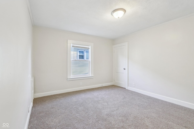 empty room featuring baseboards, carpet, and ornamental molding