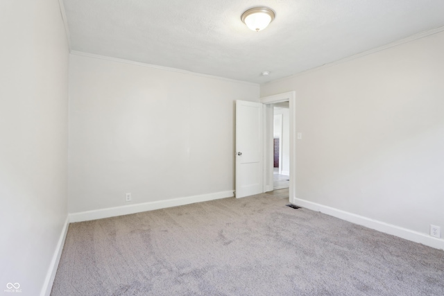 unfurnished room featuring visible vents, baseboards, crown molding, and carpet