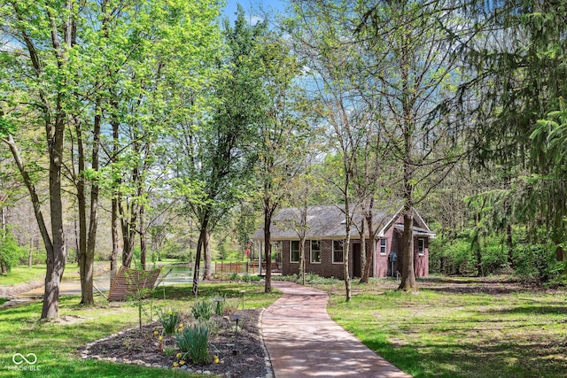 view of front facade with brick siding and a front yard