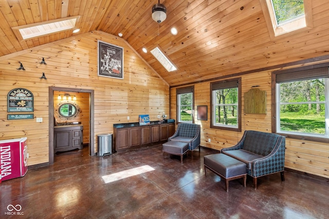 living area featuring a skylight, concrete floors, and wooden walls