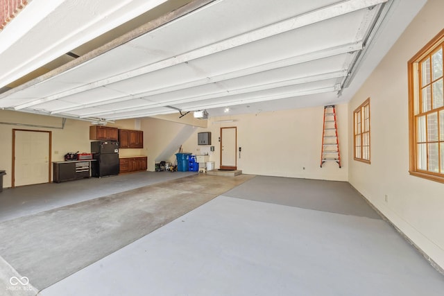 garage with freestanding refrigerator and a garage door opener