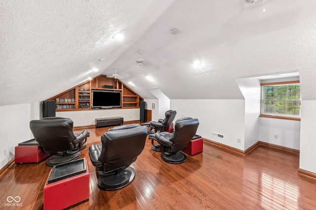 office space with visible vents, a textured ceiling, vaulted ceiling, and hardwood / wood-style flooring