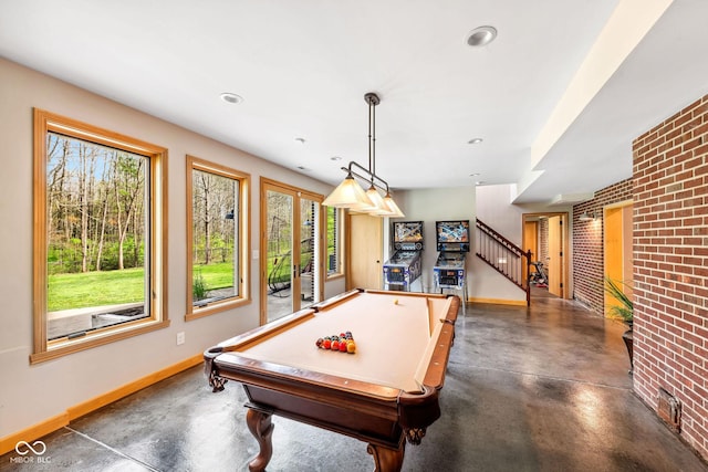 playroom featuring baseboards, concrete floors, and a healthy amount of sunlight