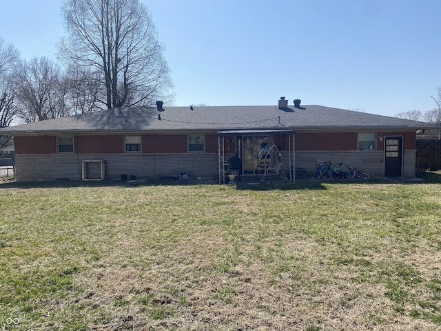 back of house featuring a lawn and roof with shingles