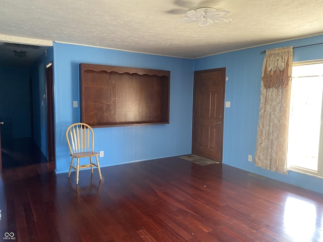 unfurnished room featuring wood finished floors, visible vents, and a healthy amount of sunlight