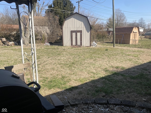 view of yard featuring an outbuilding, fence, and a shed