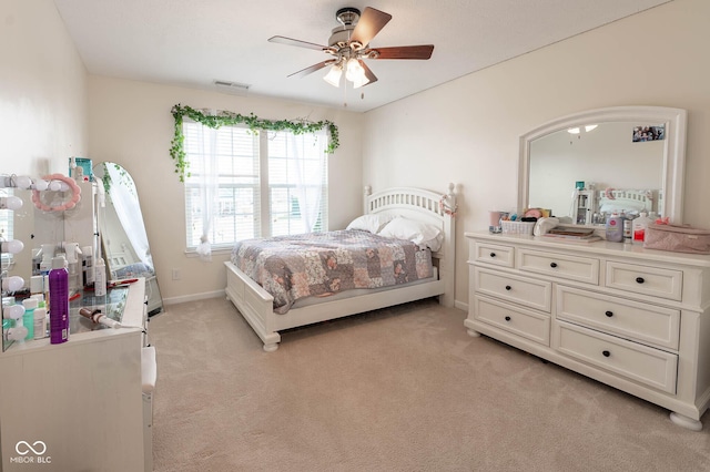 bedroom with arched walkways, light colored carpet, visible vents, and baseboards