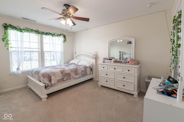 bedroom with a ceiling fan, baseboards, visible vents, and light carpet