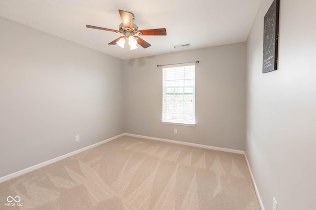 empty room featuring a ceiling fan, baseboards, visible vents, and light carpet