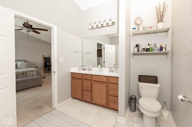 ensuite bathroom with ceiling fan, double vanity, toilet, and a sink