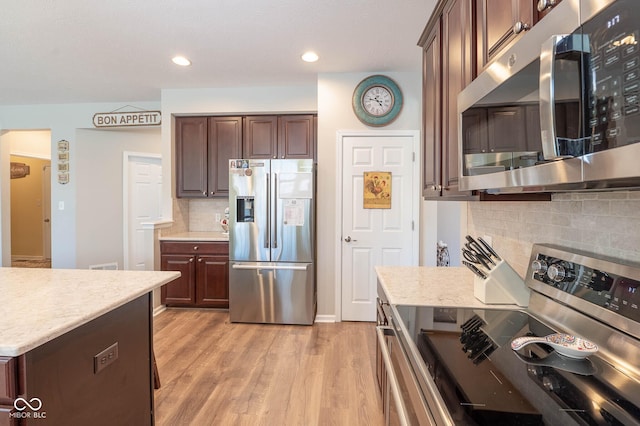 kitchen featuring recessed lighting, stainless steel appliances, dark brown cabinetry, and light wood-style flooring