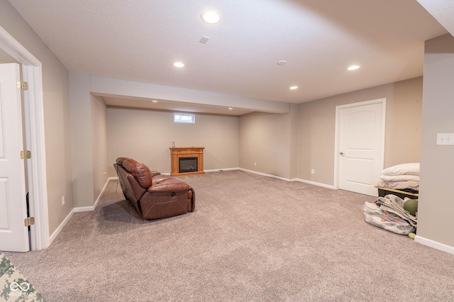 sitting room with a glass covered fireplace, recessed lighting, carpet, and baseboards