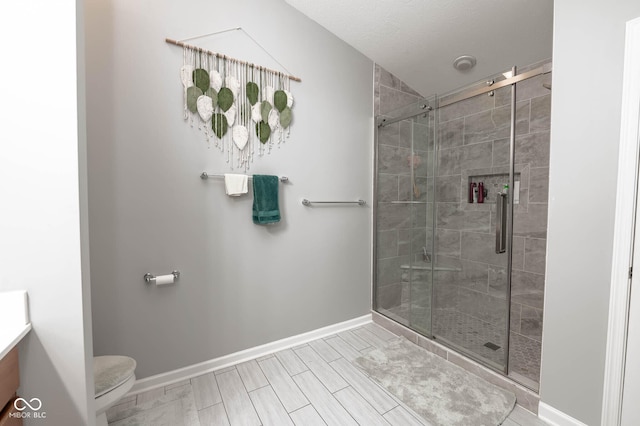 full bath featuring vanity, toilet, baseboards, and a stall shower