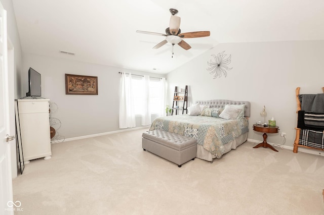 bedroom with lofted ceiling, light colored carpet, visible vents, and baseboards