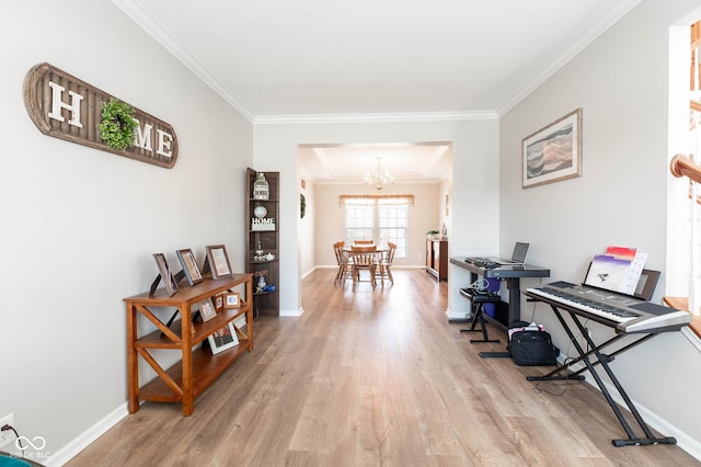 interior space with baseboards, light wood-style floors, a chandelier, and ornamental molding