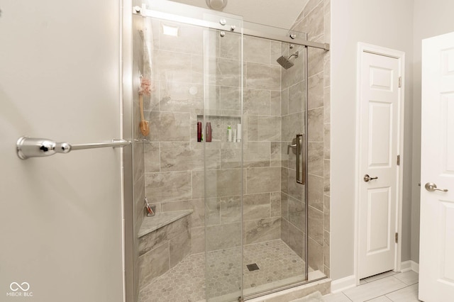 bathroom with tile patterned flooring and a shower stall