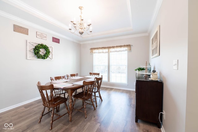 dining area with baseboards, a raised ceiling, an inviting chandelier, and wood finished floors