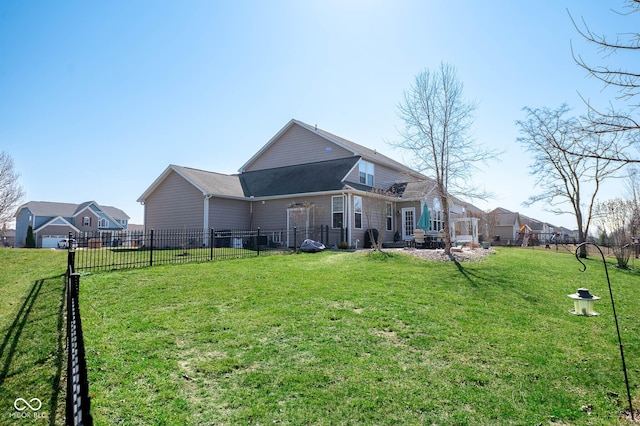 back of property featuring a lawn and fence