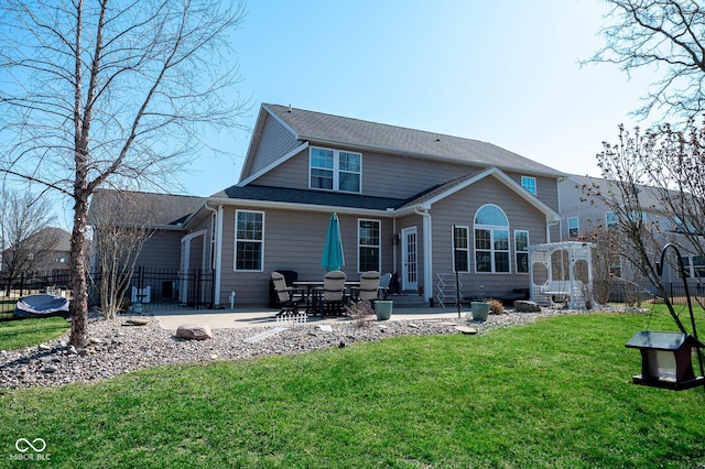 rear view of property featuring entry steps, a patio area, a yard, and fence