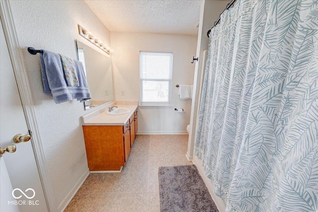 full bath featuring baseboards, toilet, a shower with shower curtain, vanity, and a textured ceiling