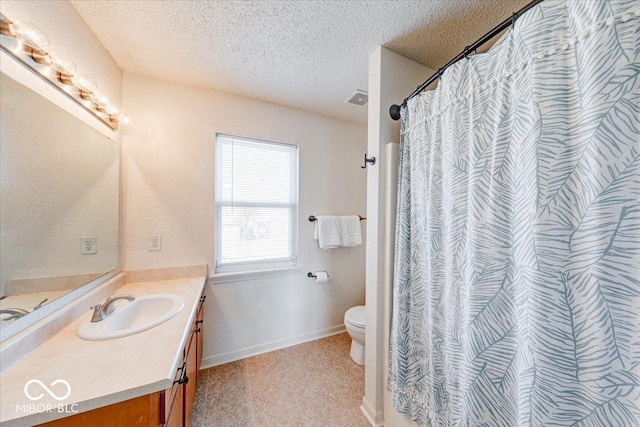 bathroom with visible vents, baseboards, toilet, vanity, and a textured ceiling