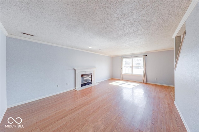 unfurnished living room with visible vents, baseboards, ornamental molding, a fireplace, and light wood-style floors