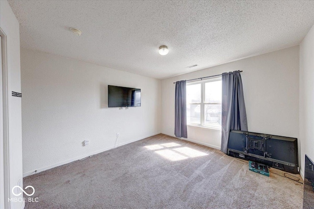 carpeted empty room featuring baseboards and a textured ceiling