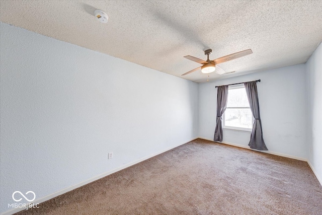 empty room with a textured ceiling, baseboards, carpet, and ceiling fan