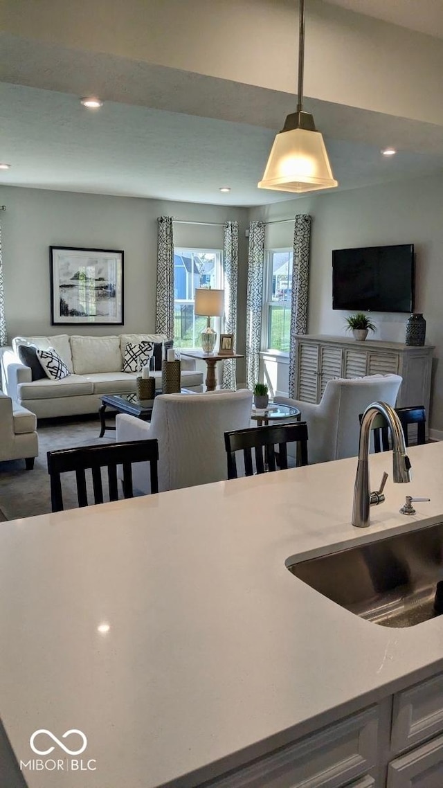 kitchen featuring a sink, decorative light fixtures, open floor plan, and recessed lighting