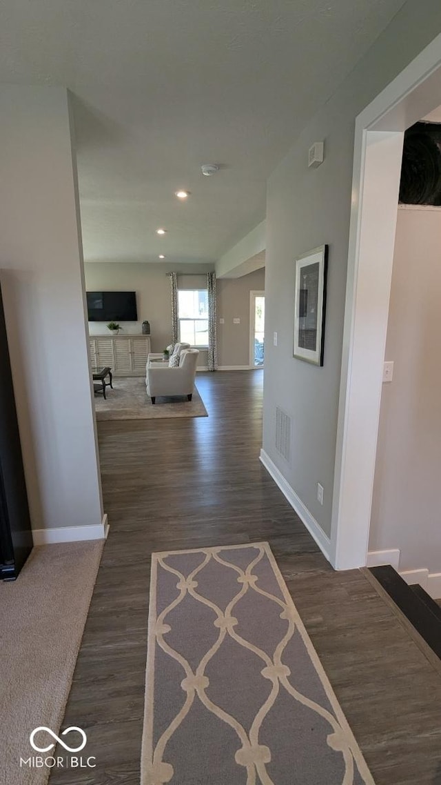 hall featuring dark wood-style floors, visible vents, recessed lighting, and baseboards