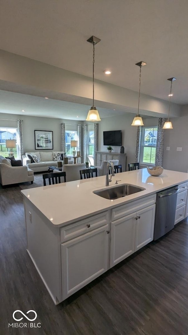 kitchen with a sink, open floor plan, dishwasher, white cabinets, and dark wood-style flooring