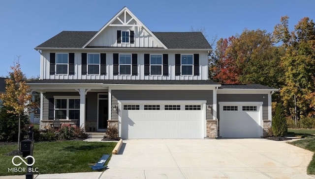 craftsman house featuring board and batten siding, stone siding, and driveway