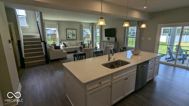 kitchen featuring a sink, dark wood-type flooring, stainless steel dishwasher, and white cabinetry