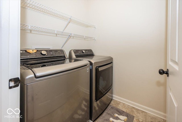 clothes washing area featuring laundry area, baseboards, and independent washer and dryer