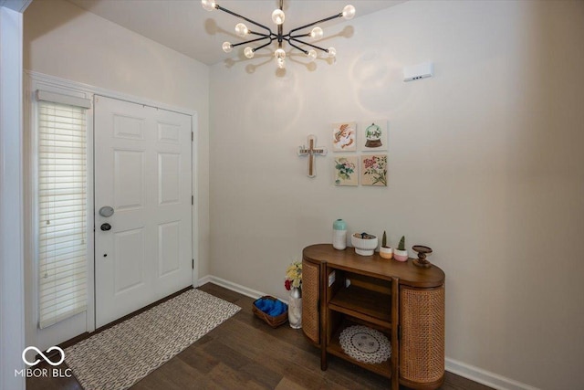 foyer entrance with baseboards, a notable chandelier, and wood finished floors