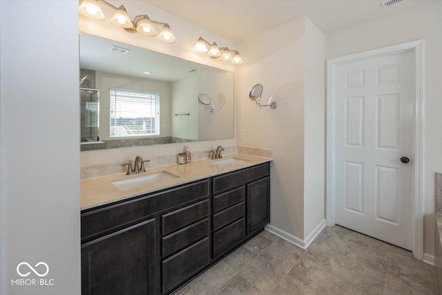 full bathroom featuring double vanity, baseboards, visible vents, and a sink