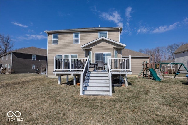 rear view of property featuring a playground, a lawn, and a wooden deck