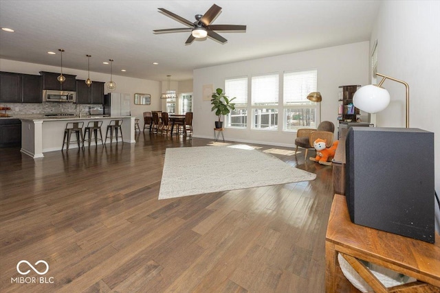 living area with recessed lighting, baseboards, ceiling fan, and dark wood-style flooring