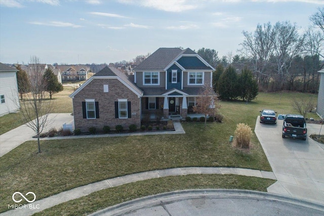 view of front of home featuring a front yard, brick siding, and driveway